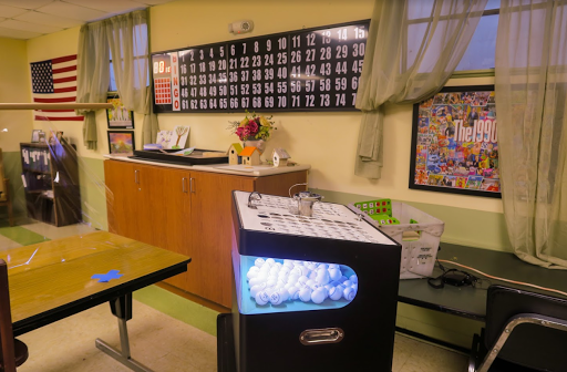 A cozy classroom setup featuring a bingo machine and a decorated wall, creating an inviting educational atmosphere.