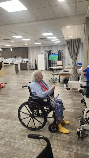 A senior individual in a wheelchair participates in activities at a rehabilitation center.