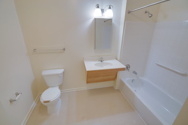 A clean, white bathroom with a sink, toilet, and bathtub.