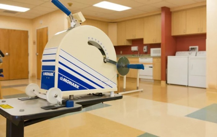 A specialized exercise machine in a gym setting designed for rehabilitation purposes.