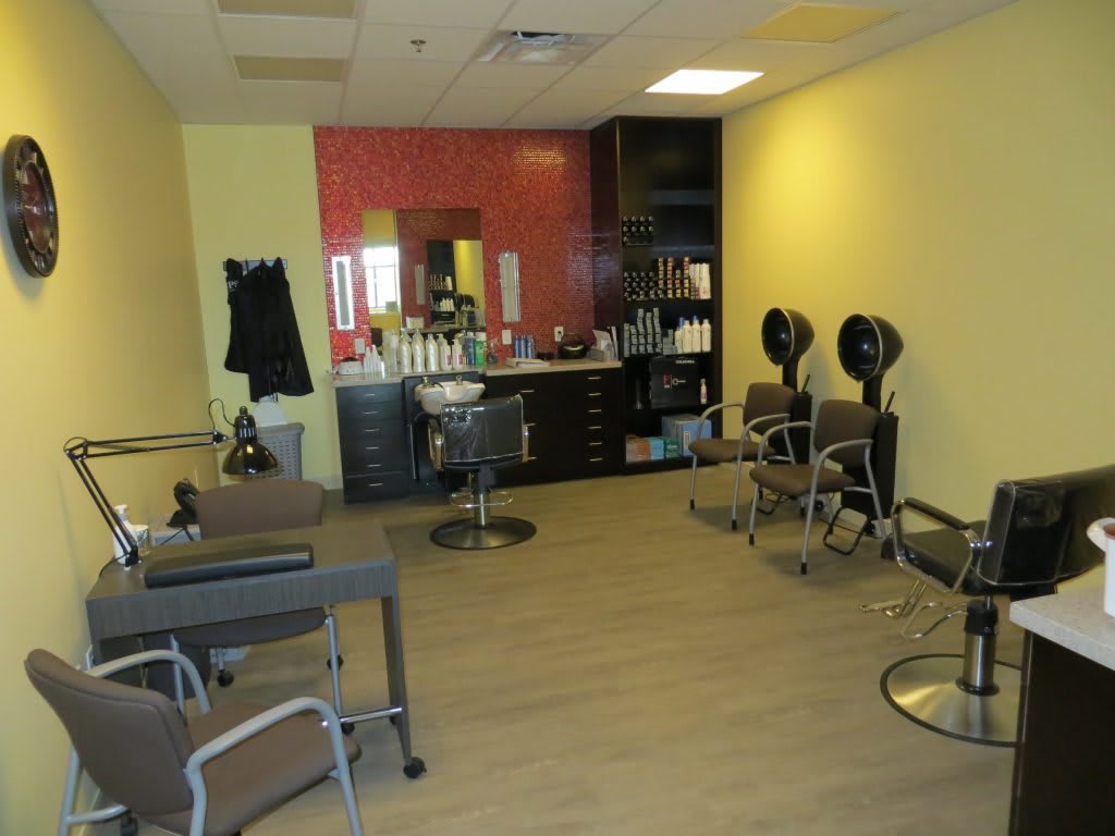 An interior view of a hair salon featuring chairs, mirrors, and salon equipment.