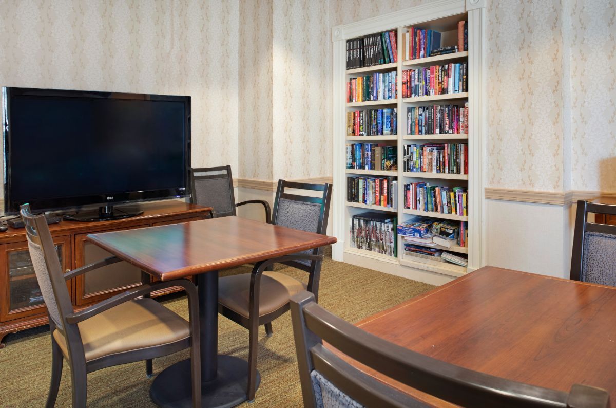 A cozy meeting room with a bookshelf and a television.