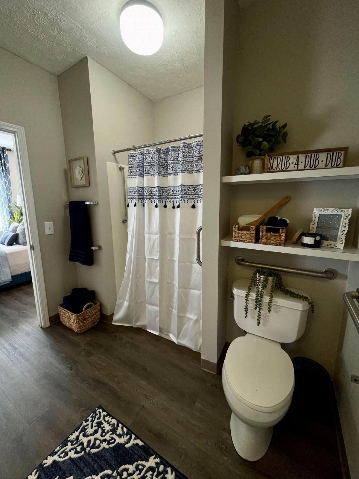 A modern bathroom with elegant decor, featuring a shower curtain, toilet, and organized shelves.