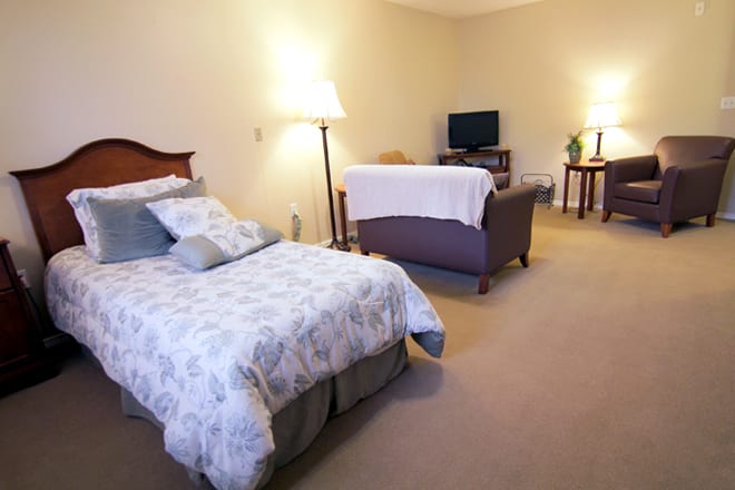 A cozy bedroom with a bed, sofa, and television creating a comfortable living space.