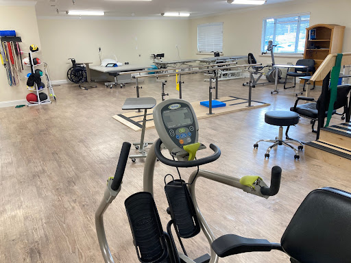 A spacious physical therapy gym equipped with various exercise equipment.