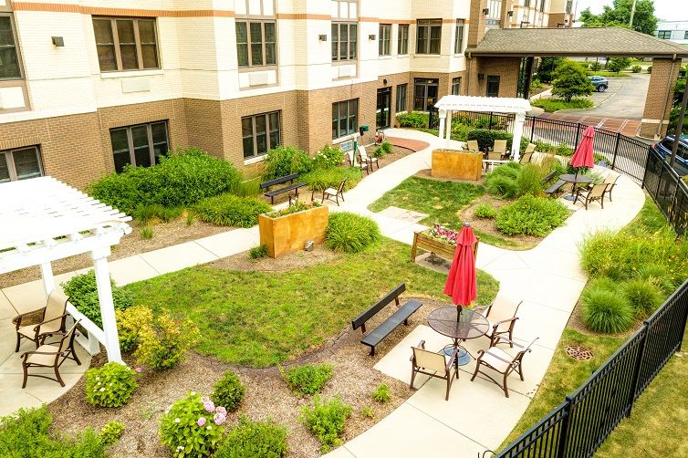 A well-maintained garden area with benches and outdoor seating outside a building.