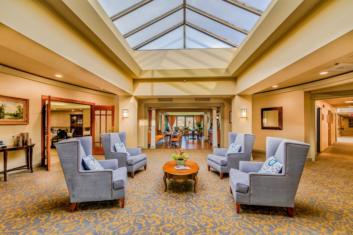 A modern lobby with comfortable armchairs and a skylight ceiling.
