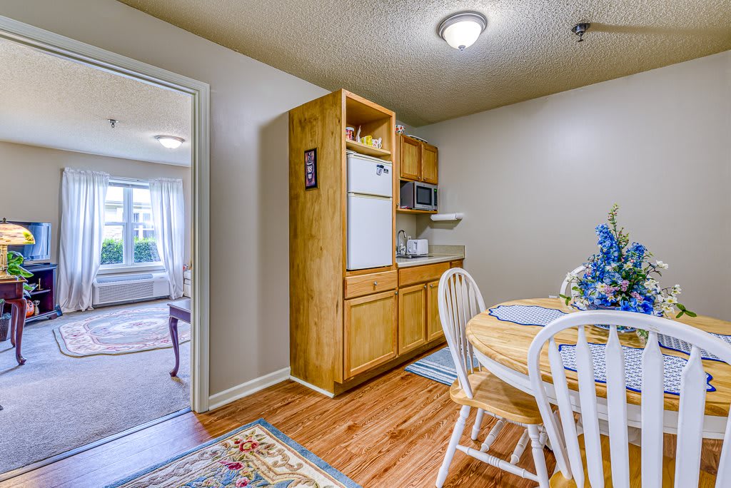 A cozy kitchen with wooden cabinets and a small dining area featuring a round table and chairs.