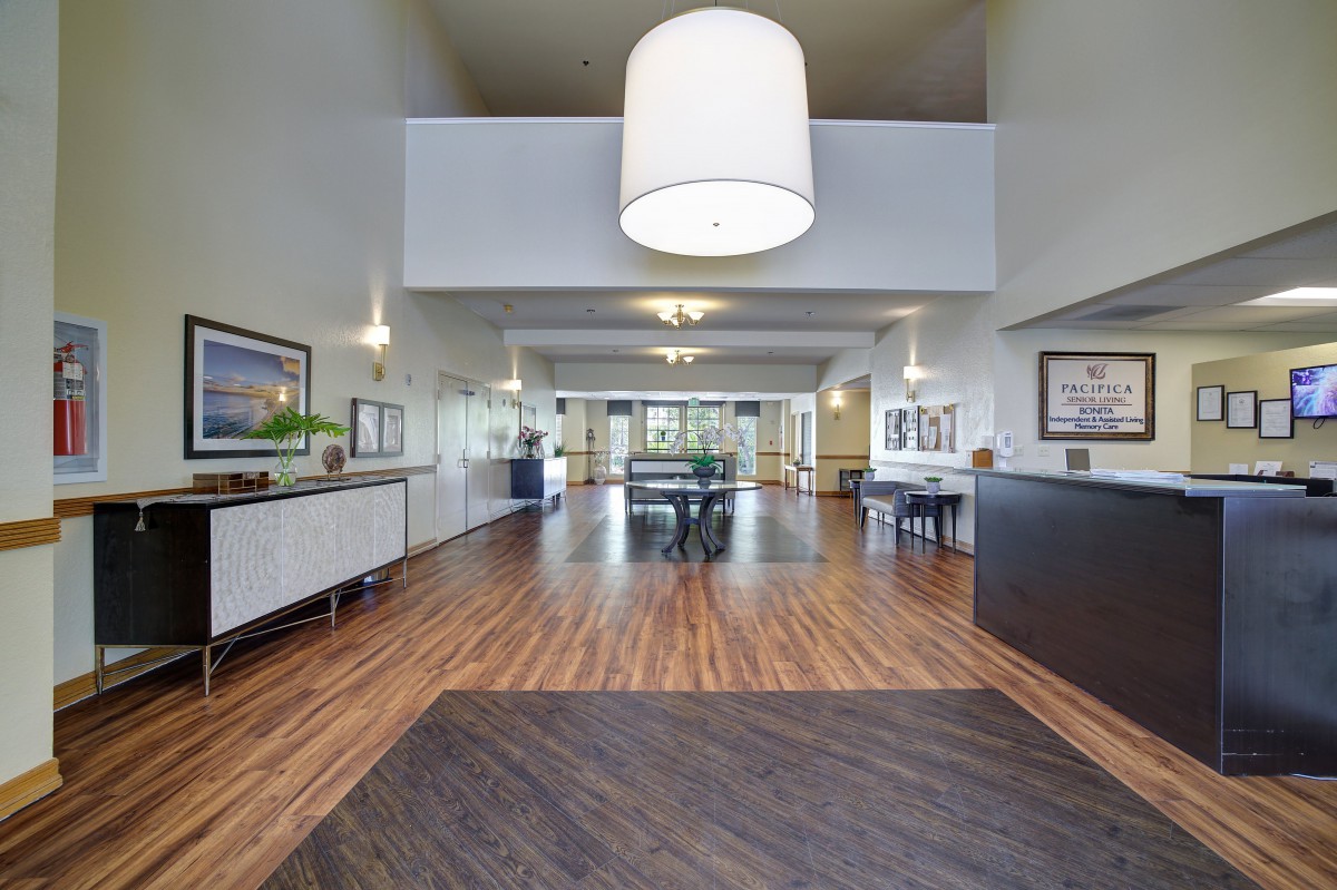 A spacious, modern lobby area with wooden flooring and contemporary furnishings.
