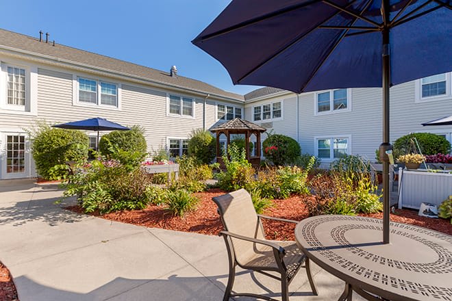 A sunny courtyard with seating and a landscaped garden area.