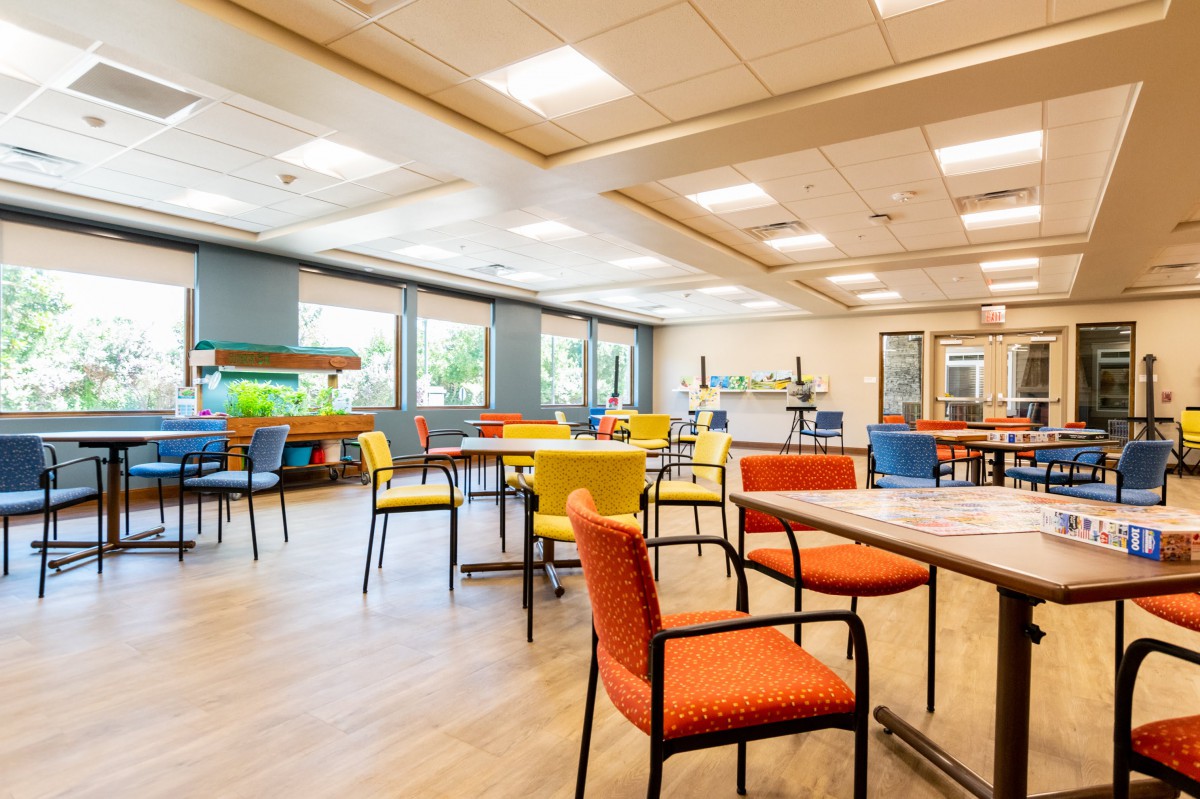 A modern, brightly lit room with colorful chairs and tables.