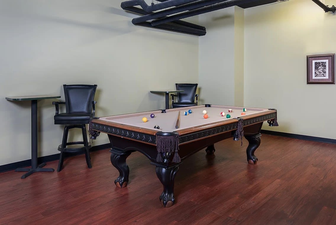 A stylish game room featuring a pool table and comfortable seating.