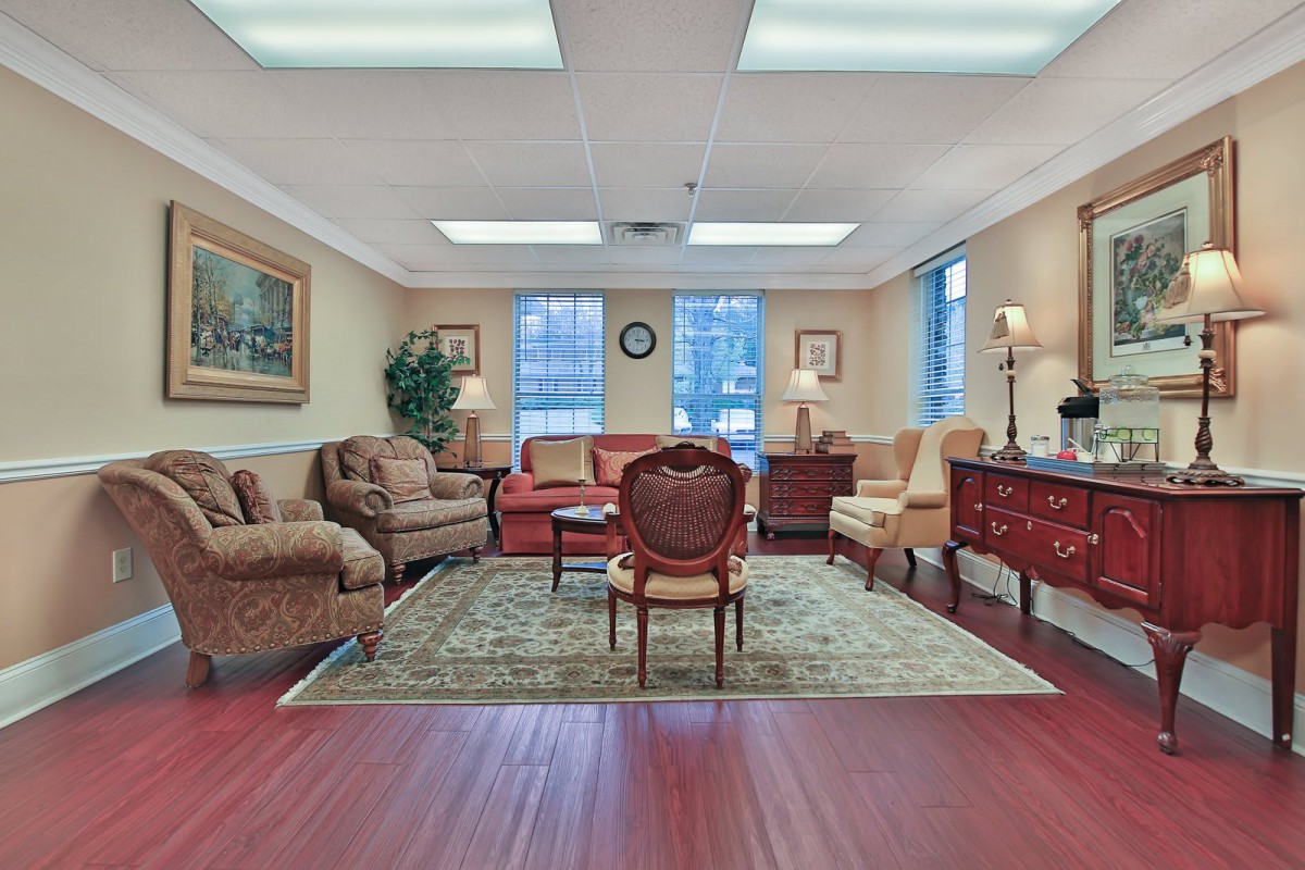 A well-furnished living room with a variety of seating options arranged around a central rug.