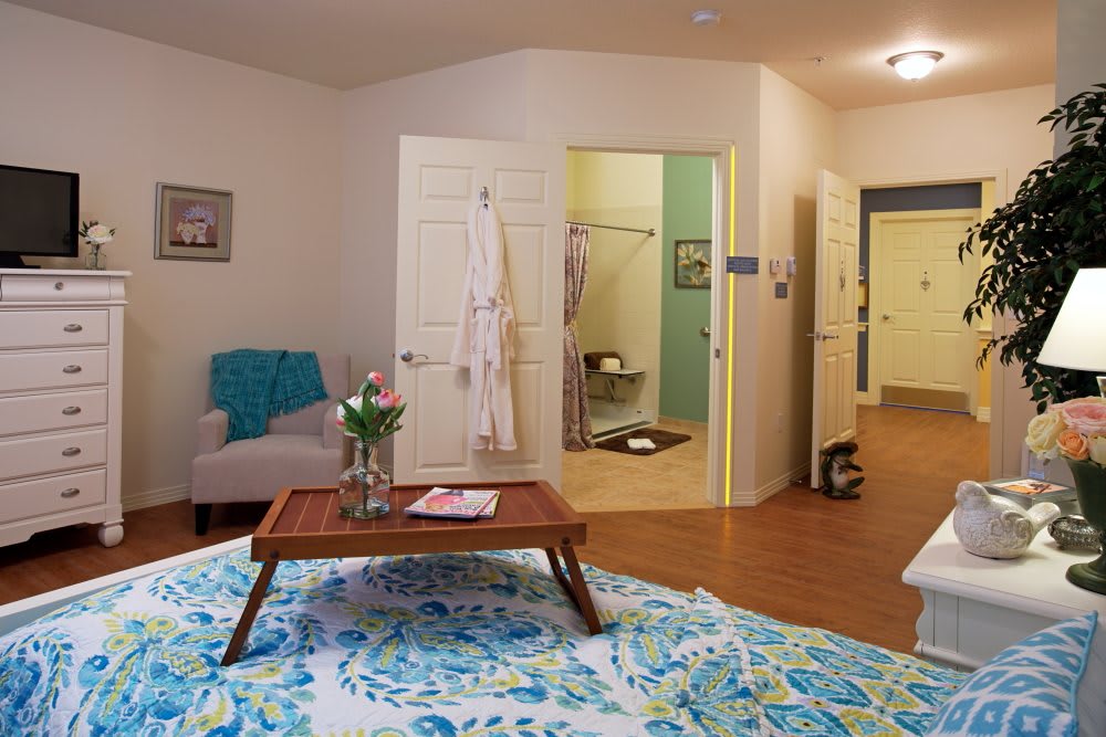 A cozy bedroom with a view into an adjoining bathroom, featuring comfortable furniture and inviting decor.