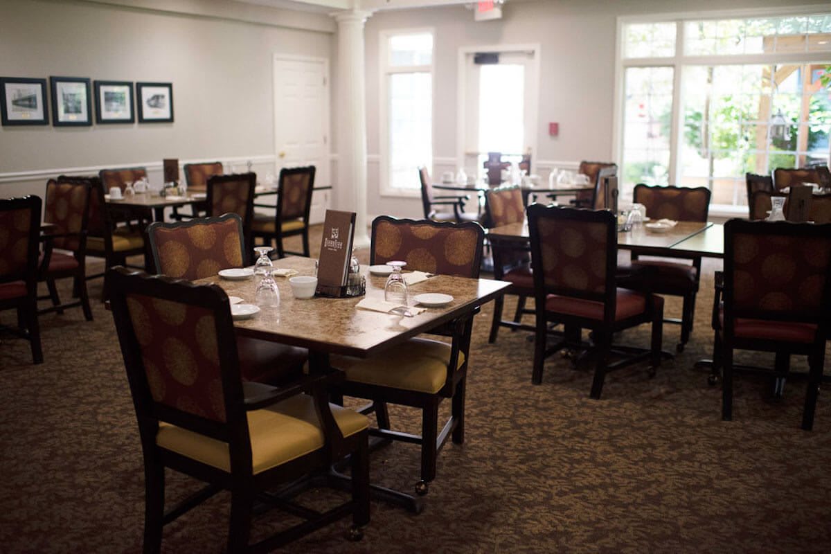 An empty dining room with neatly arranged tables and chairs.