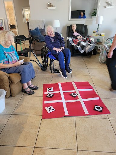 Elderly residents enjoying a game of tic-tac-toe in a community setting.