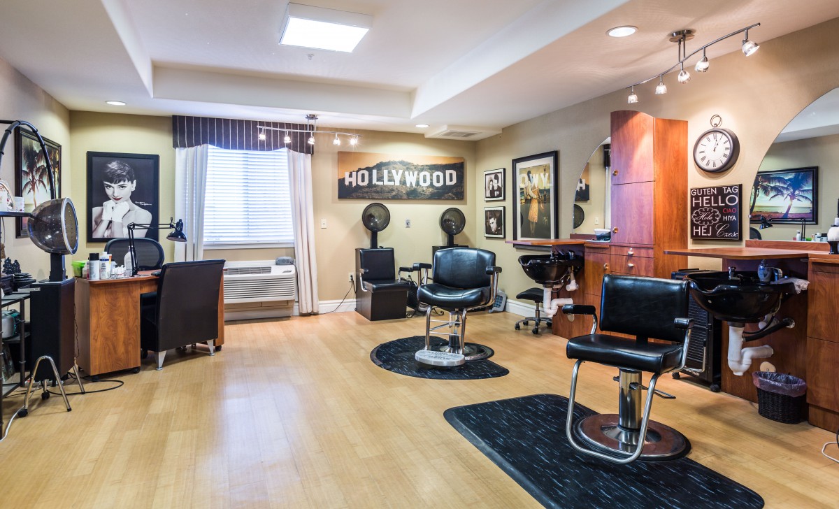 A modern hair salon with a Hollywood theme, featuring classic barber chairs and stylish interior decor.