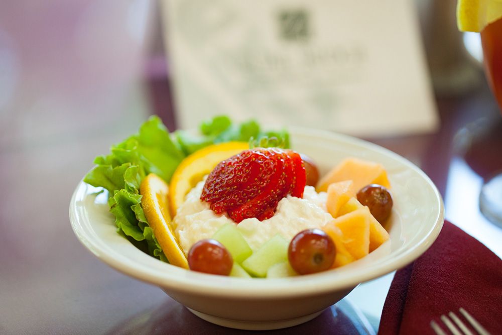 A colorful fruit salad with a variety of fresh fruits and a cream topping.