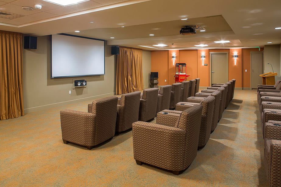 A cozy home theater room with comfortable seating and a large projection screen.