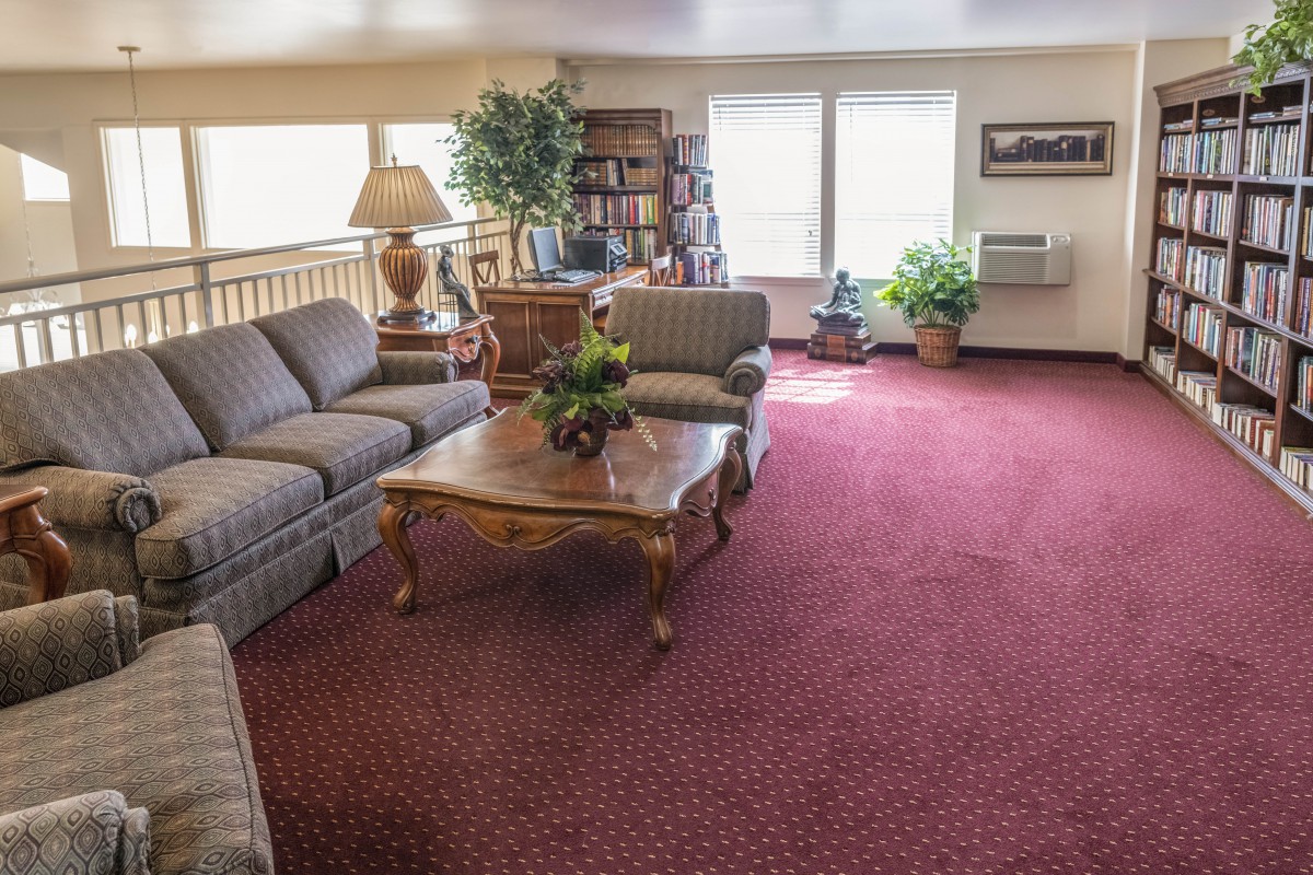 A cozy living room with comfortable seating, a coffee table, and decorative plants.
