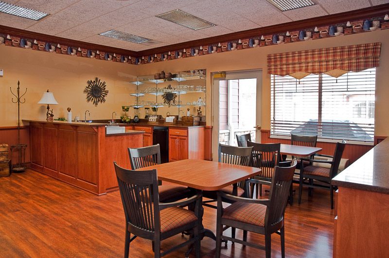 A cozy dining area with wooden tables and chairs, decorated in a warm and inviting style.