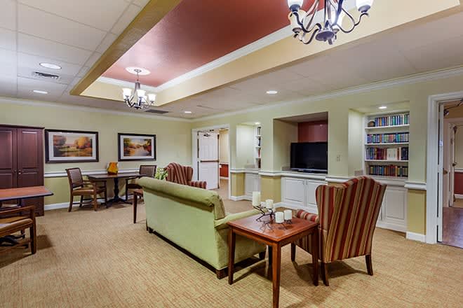 A cozy living room with sofas, chairs, and a television.