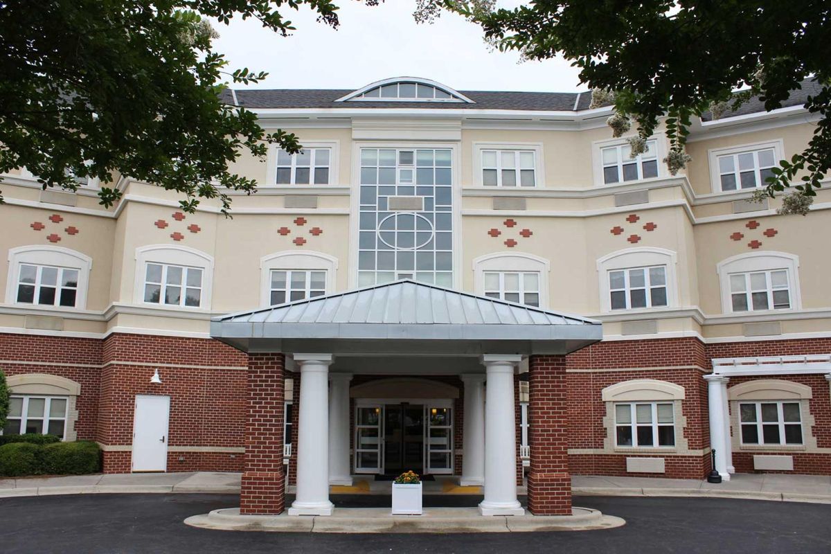 A multi-story residential building with a columned entrance.
