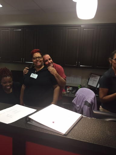 A cheerful group of individuals gathered in an office setting, enjoying each other's company.