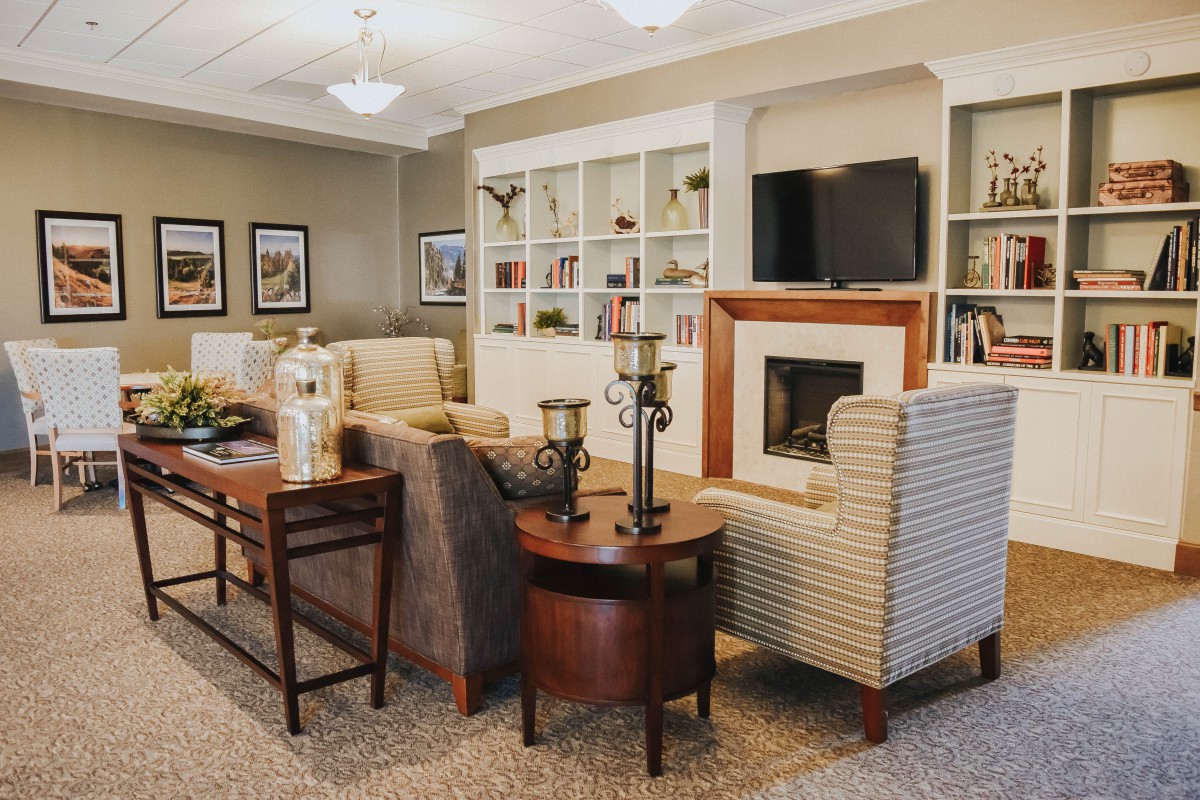 A cozy living room featuring comfortable seating, a fireplace, and built-in bookshelves.