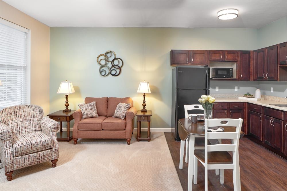 Cozy living room and kitchen area with a sofa, dining table, and modern appliances.