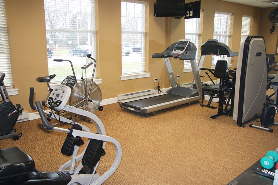 A small gym room with various exercise equipment including treadmills and stationary bikes.
