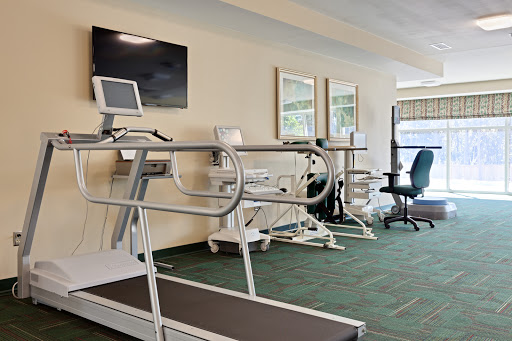 A modern fitness area featuring a treadmill and other exercise equipment.