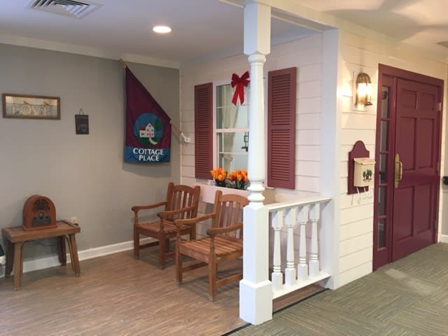 A cozy indoor porch area featuring wooden chairs and homey decorations.