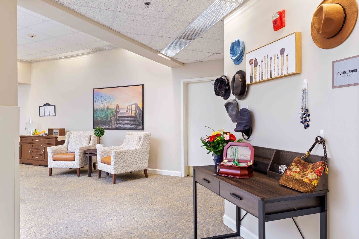 A contemporary waiting room with stylish decor, featuring a vintage radio and wall-mounted hats.