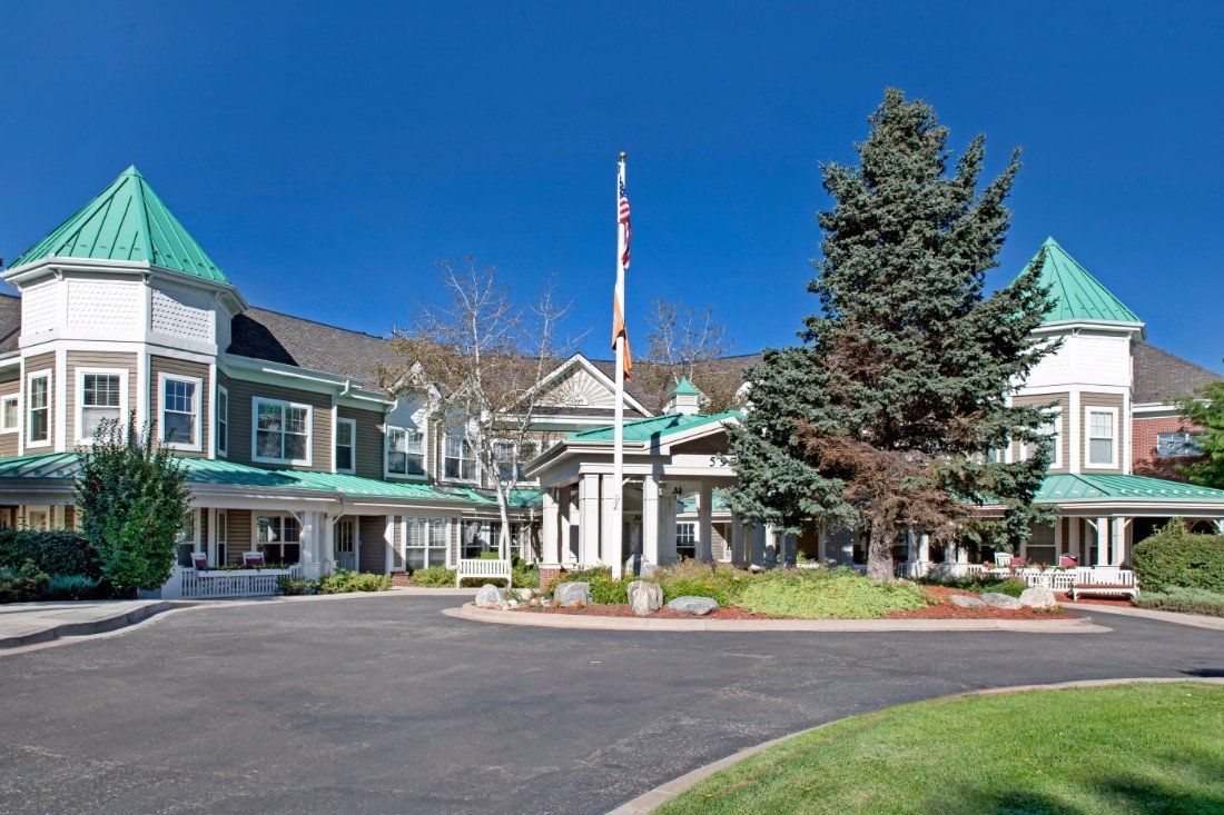 A scenic view of a hotel entrance with well-maintained landscaping and clear skies.