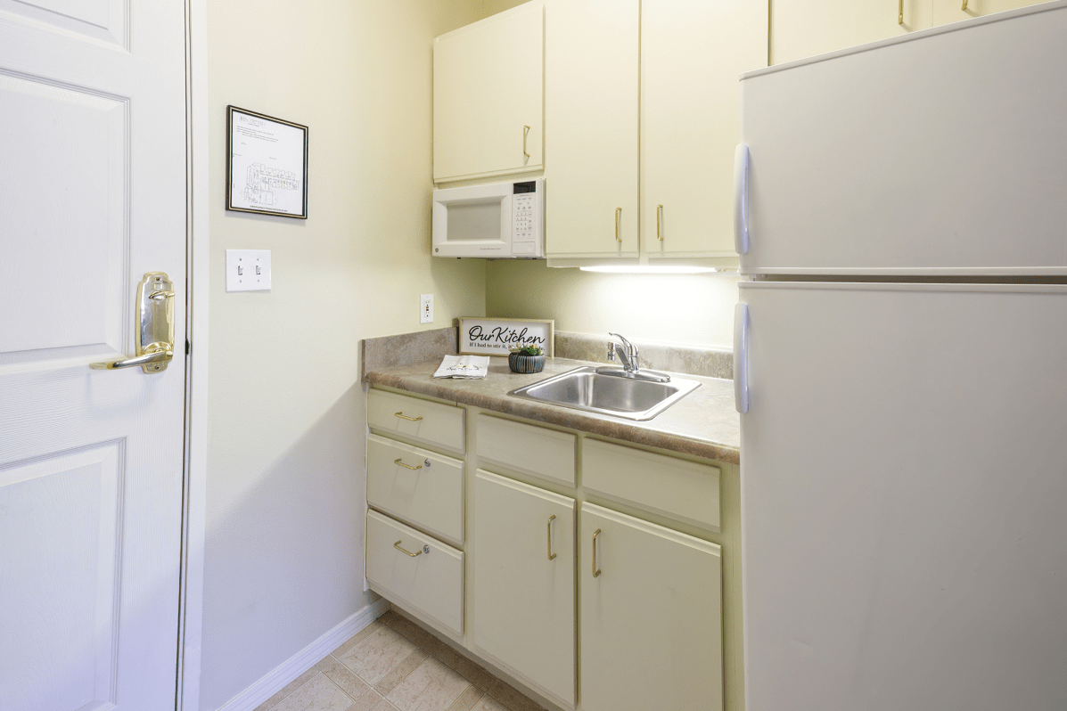 Compact apartment kitchen with cabinetry and appliances.