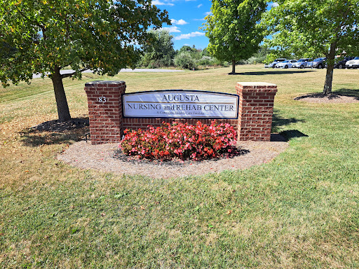 A sign marking a local institution, surrounded by well-maintained grass and flower beds.