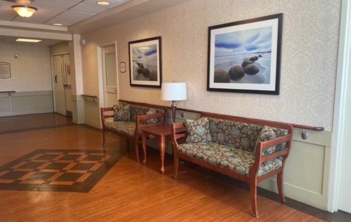 A lobby seating area with couches and framed artwork on the wall.