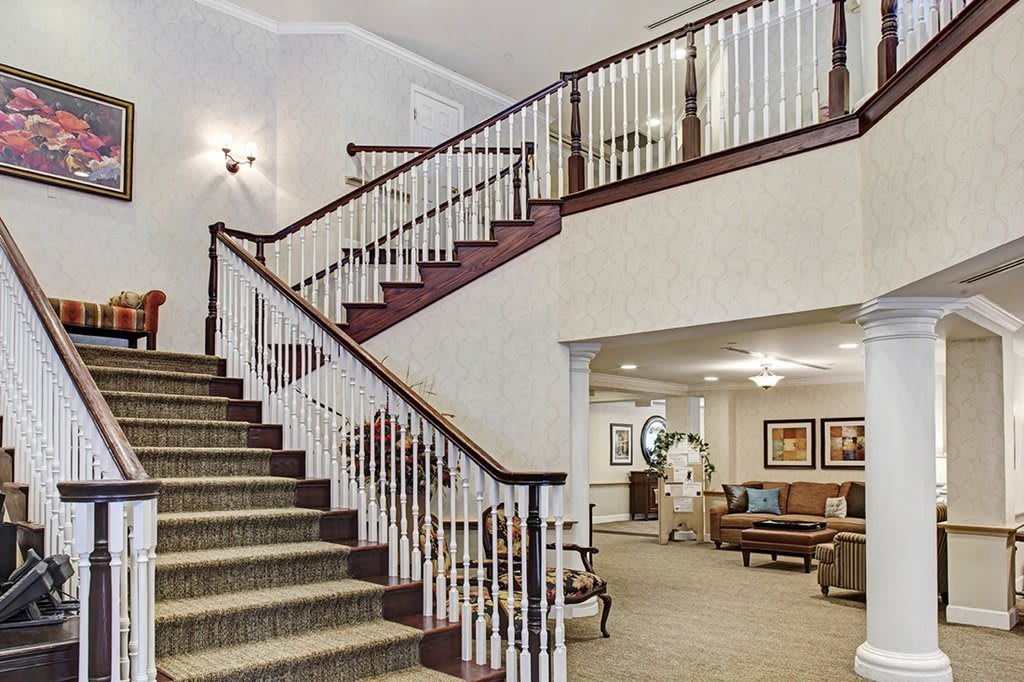 A cozy home interior featuring a grand staircase leading to a comfortable living area.