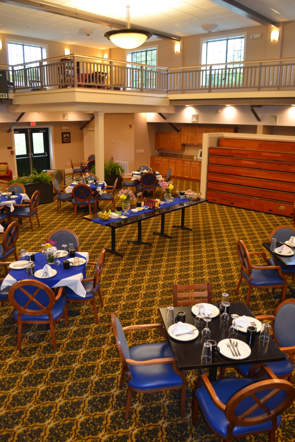 A cozy dining area with neatly arranged tables and chairs, featuring elegant decor and a patterned carpet.