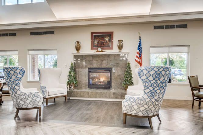 A cozy seating area featuring a fireplace, decorative chairs, and a patriotic theme with an American flag.