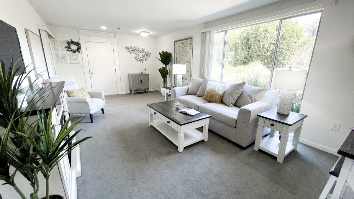 A bright and spacious living room with neutral tones and modern decor.