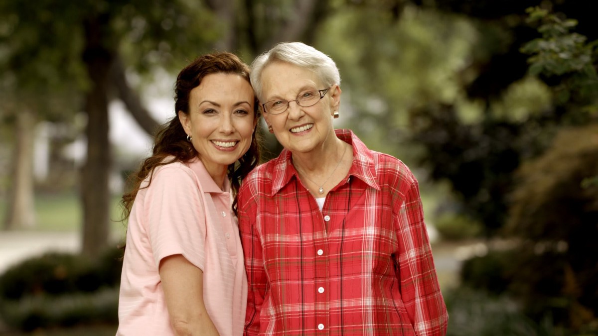 Two women smiling together in an outdoor setting.