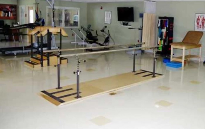 A rehabilitation room featuring balance bars for physical therapy exercises.