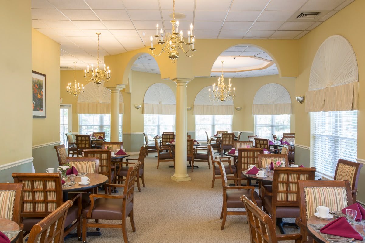 An elegant restaurant dining area with neatly arranged tables and chandeliers.