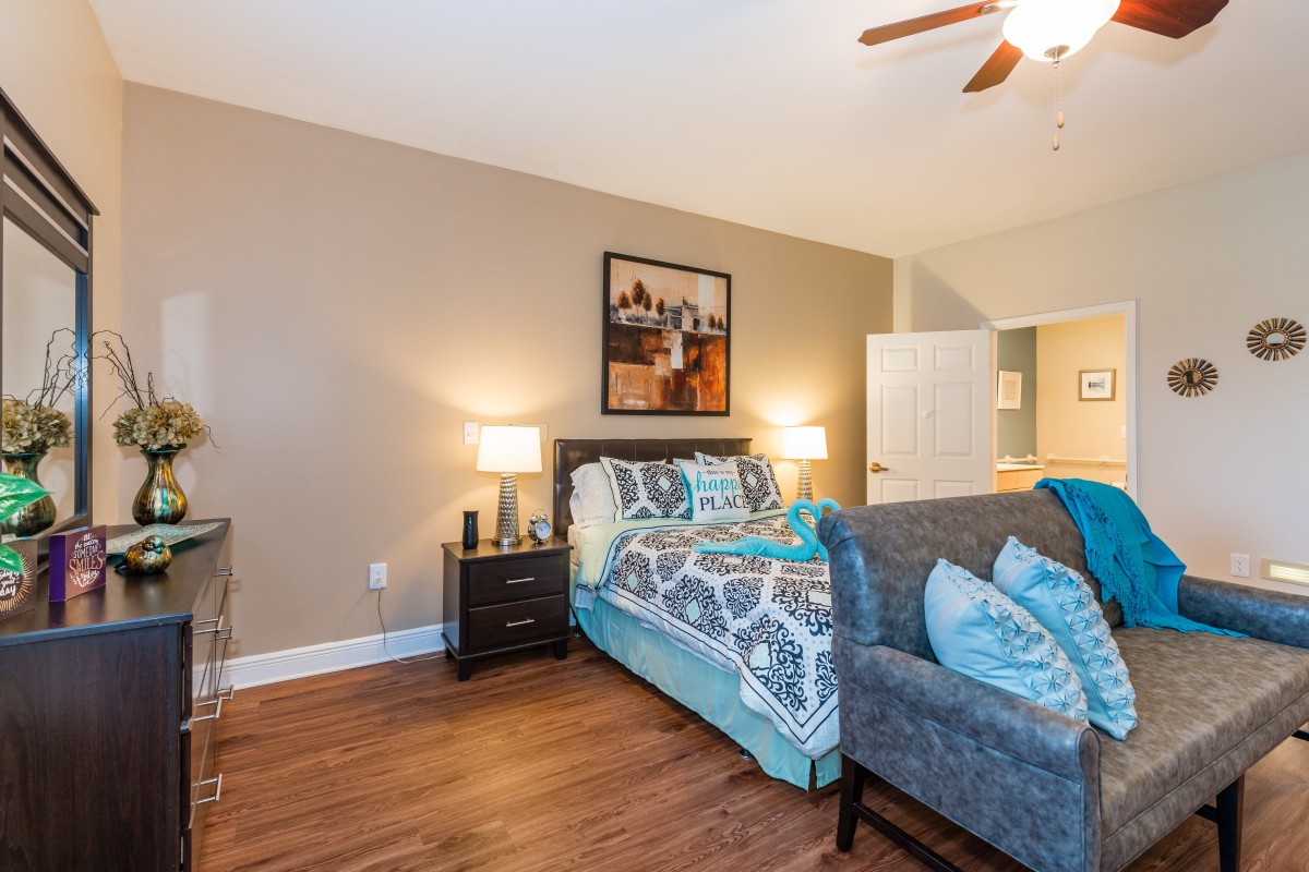 A cozy bedroom with a neatly made bed, stylish decor, and warm lighting.