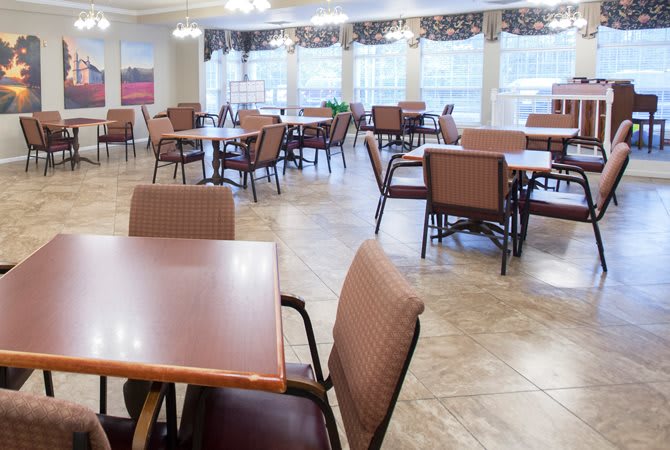 An empty dining area with several tables and chairs arranged neatly.