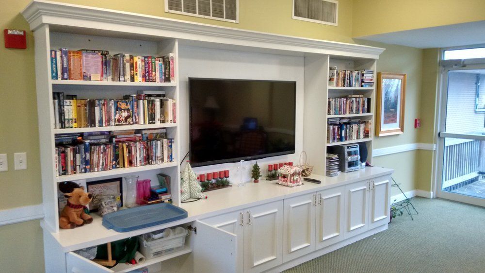 A well-organized entertainment center with shelves full of books and a large television in the living room.