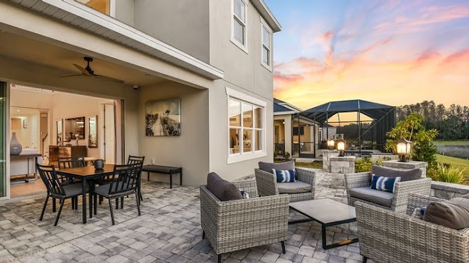 A modern outdoor patio area with comfortable seating, overlooking a beautiful sunset.