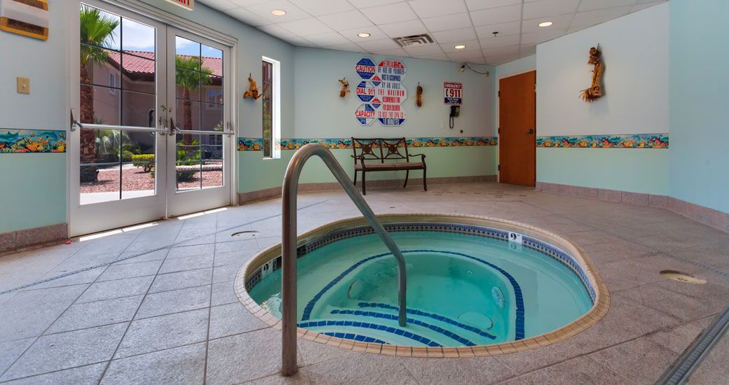 A cozy indoor hot tub area with a bench and natural light.